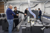 A photograph of the R&J Machinery team helping a customer to demo a machine